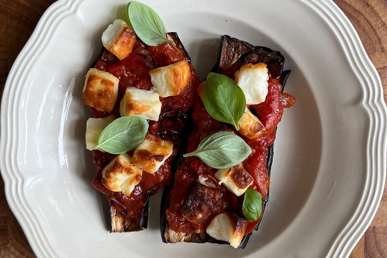 Pieczony bakłażan z sosem z pieczonych pomidorów i czosnku z serem halloumi.
